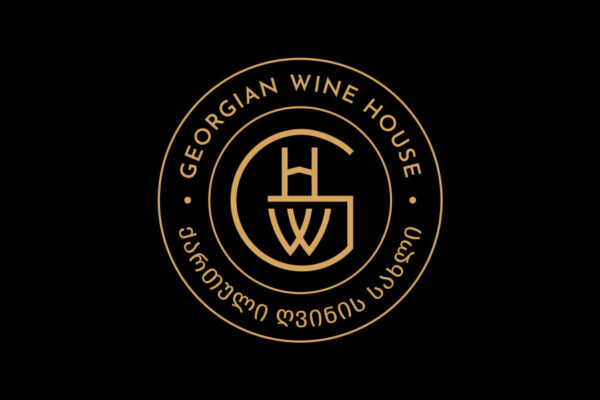 A gold and black circular logo for Georgian Wine House featuring stylized text and a monogram.